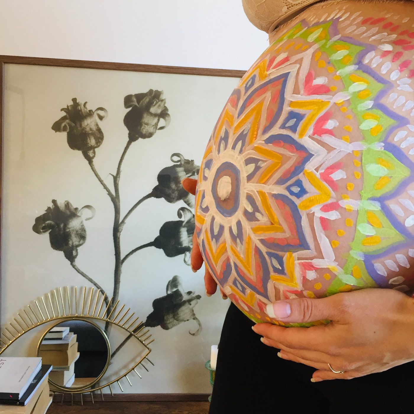 Colourful mandala painted on a pregnant belly, side view