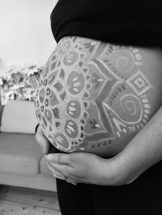 White mandala on a pregnant belly, side view, black and white