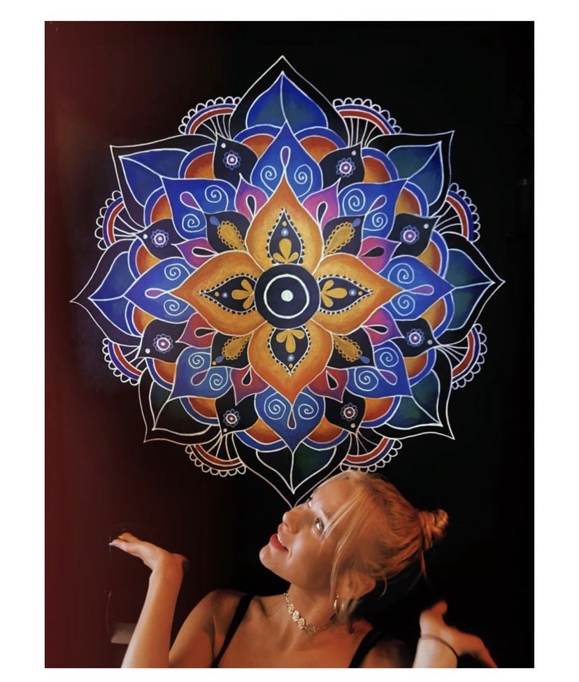 Lasma sitting below her white mandala